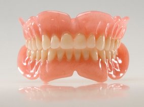 a set of removable dentures against a gray background